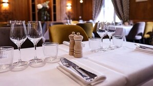 A dining table set with wine glasses, water glasses, and salt and pepper shakers. - Hotel la grand mare  (Conches-en-Ouche)