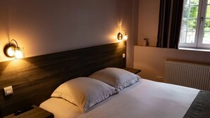 A neatly made bed with white linens, two bedside tables, and wall-mounted reading lamps. - Hotel la grand mare  (Conches-en-Ouche)