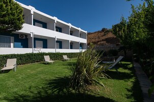 Un bâtiment moderne doté de nombreux balcons, d’une pelouse bien entretenue et d’espaces aménagés pour se détendre en plein air.