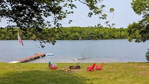 Un cadre idyllique au bord du lac, avec un quai, un foyer et plusieurs chaises.