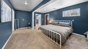 Une chambre à coucher avec un lit, une chaise, un bureau et une fenêtre.