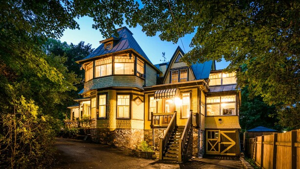 A large, multi-story building with a prominent tower and a covered porch area. - Victorian inn dating from 1864 with spa - sleeps 18 (WATERLOO)