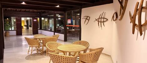A modern interior with wicker furniture and a glass wall.