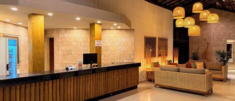 A reception area with a wooden reception desk, a computer, and a seating area with a sofa and chairs.