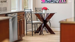 Una cocina moderna con armarios de madera, una mesa de comedor con sillas y una gran obra de arte con temática de París en la pared.