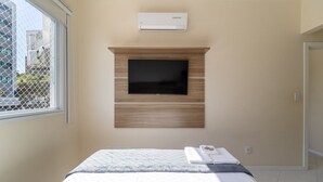 A bedroom with a bed, a mounted TV, and an air conditioning unit. - 2 Bedroom Apartment With Barbecue Cts0203 (Florianópolis)