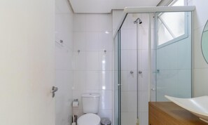 A bathroom with a glass shower enclosure, a toilet, and a sink with a wooden countertop. - 2 Bedroom Apartment With Barbecue Cts0203 (Florianópolis)