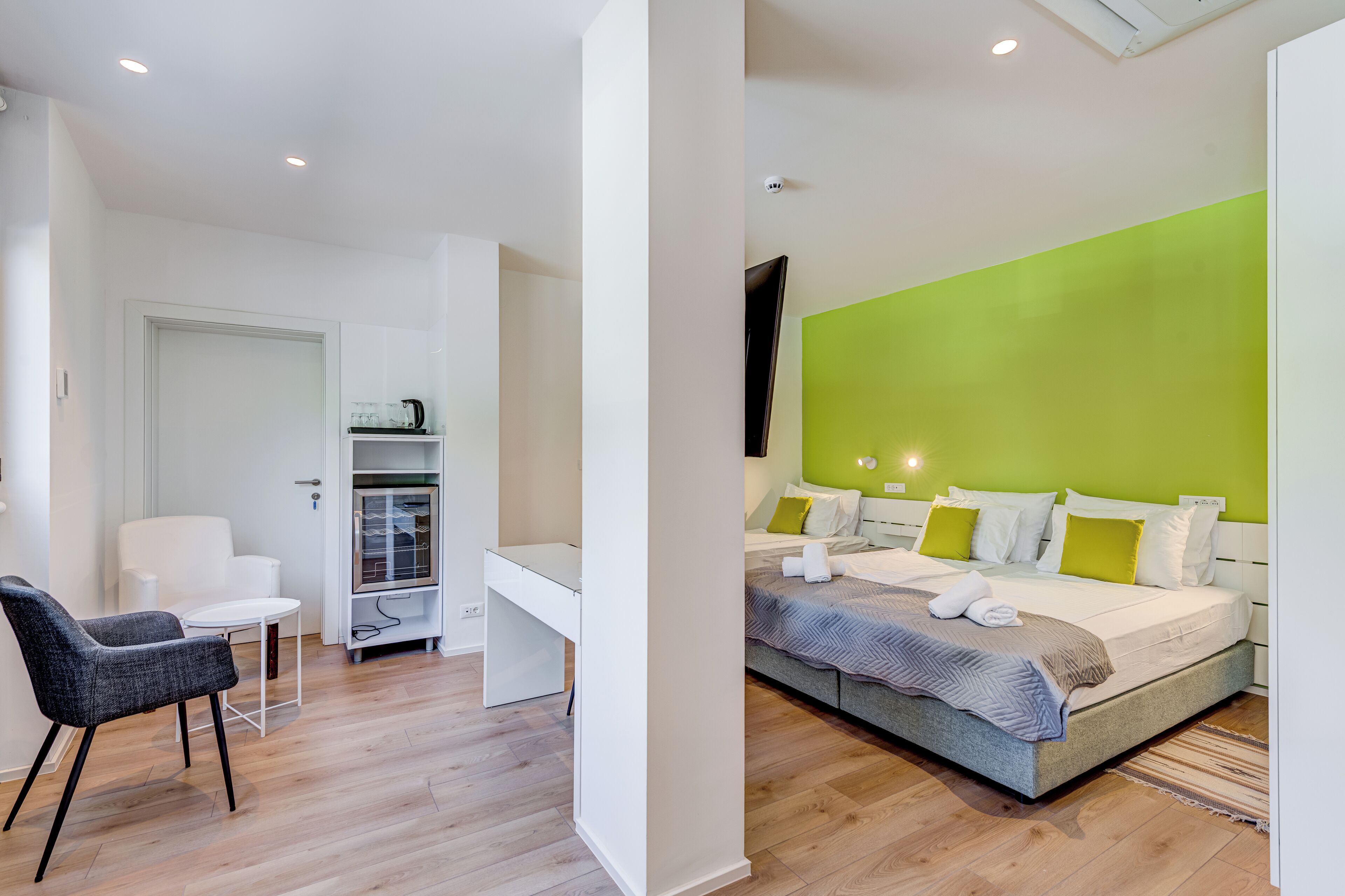 Une chambre d’hôtel moderne, équipée d’un lit, d’un bureau et d’une chaise.