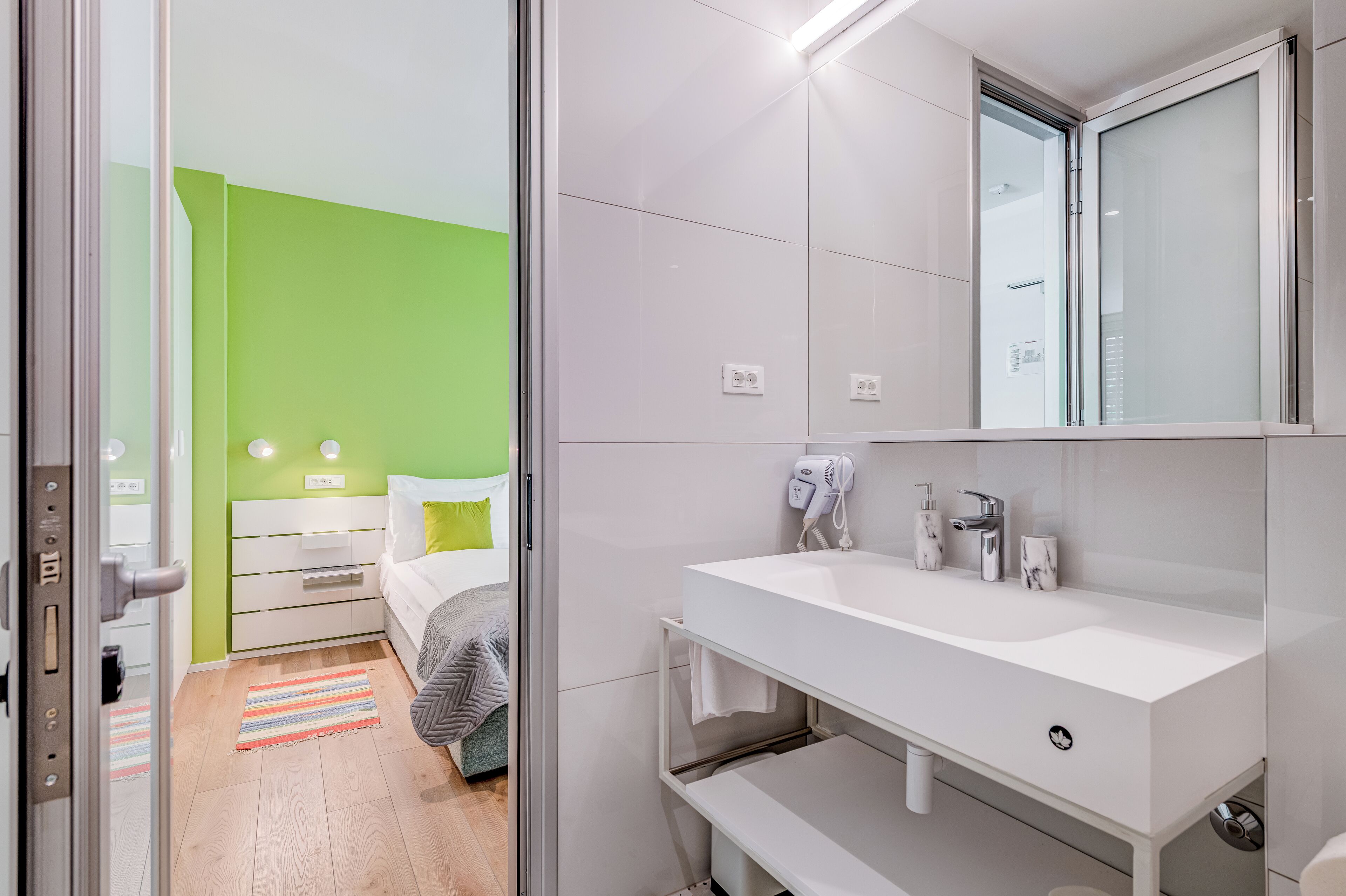 A modern bathroom with a white sink, mirror, and towel rack.