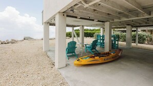 A covered outdoor seating area with chairs and a kayak.