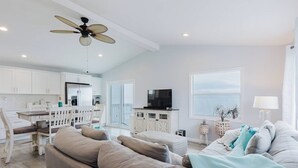 A modern living room with a sofa, TV, and dining area.