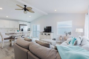 A modern living room with a sofa, TV, and dining area. - Private waterfront escape! Open water views & kayaks. Come sail away (Marathon)