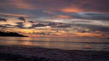 A beach with waves at sunset.