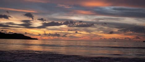 A beach with waves at sunset.