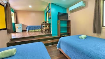 A hotel room with two beds, a desk, a chair, a TV, and a staircase leading to another room.