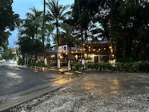 A building with a tiled roof, surrounded by palm trees, and a sign indicating a restaurant. - Hotel Brasilito (Cabo Velas)