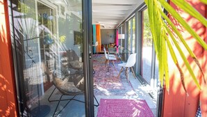A modern interior with a glass door leading to a dining area with chairs and a table. - Seaside Dream House 3bed/2bath single family with open water views (Marathon)