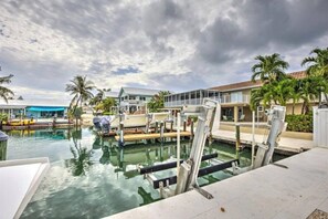 Ein Yachthafen mit vertäuten Booten, einem Schwimmbad und einem Gebäude mit Balkon.