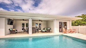 A poolside area with a pool, chairs, and a covered seating area. - Splash Into Me! New 3 BR in Key Colony w/ dockage + private pool (KEY COLONY BEACH)