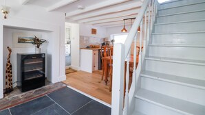 Un vaste espace de vie comprenant un escalier, un coin repas et une cuisine.