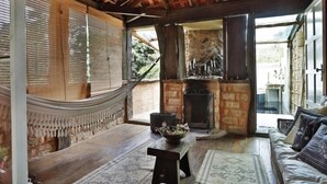 A cozy living room with a wooden floor, a sofa, a table with a bowl, and a fireplace.
