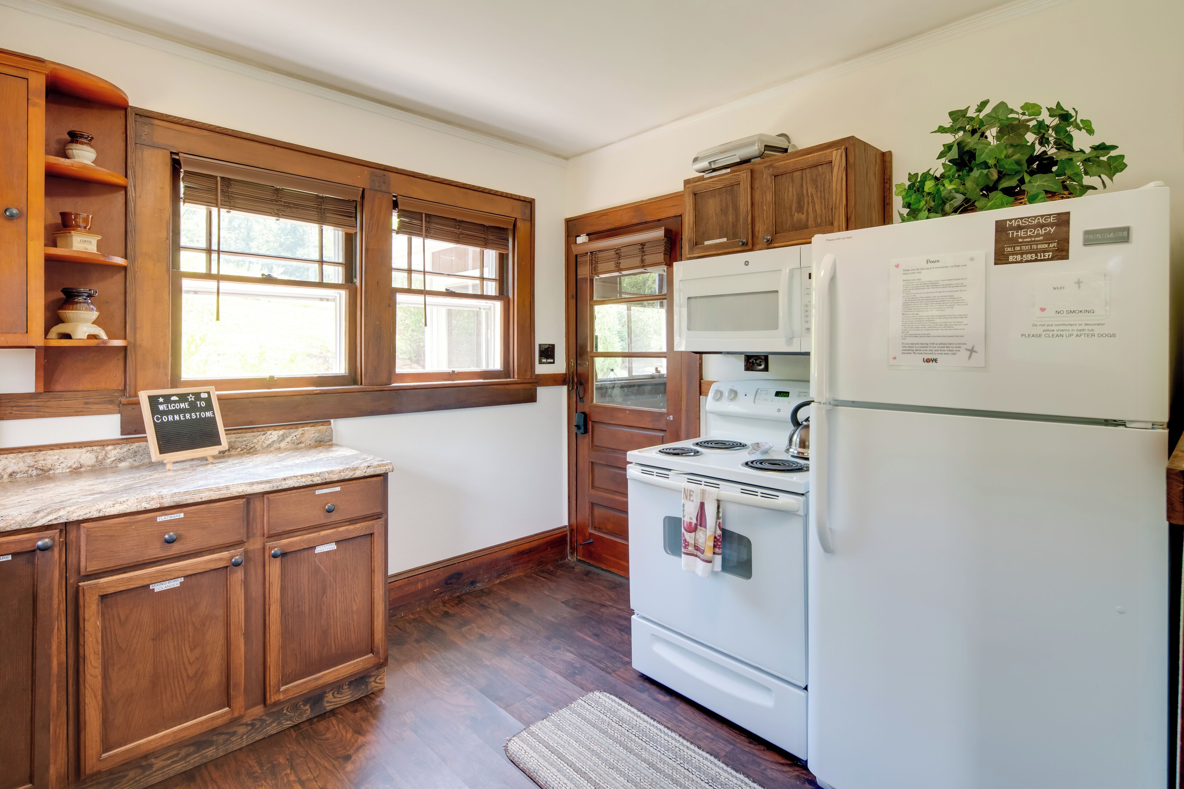 A kitchen with wooden cabinets, a white refrigerator, a stove, and a microwave.