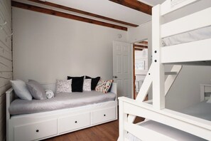 A white bunk bed with a lower bunk and a white headboard.