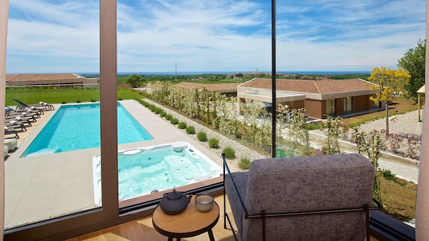 A balcony with a view of a swimming pool, a hot tub, and a landscaped garden. - Luxury villa with pool and panoramic views - the perfect vacation in the heart of Istria (Brtonigla)