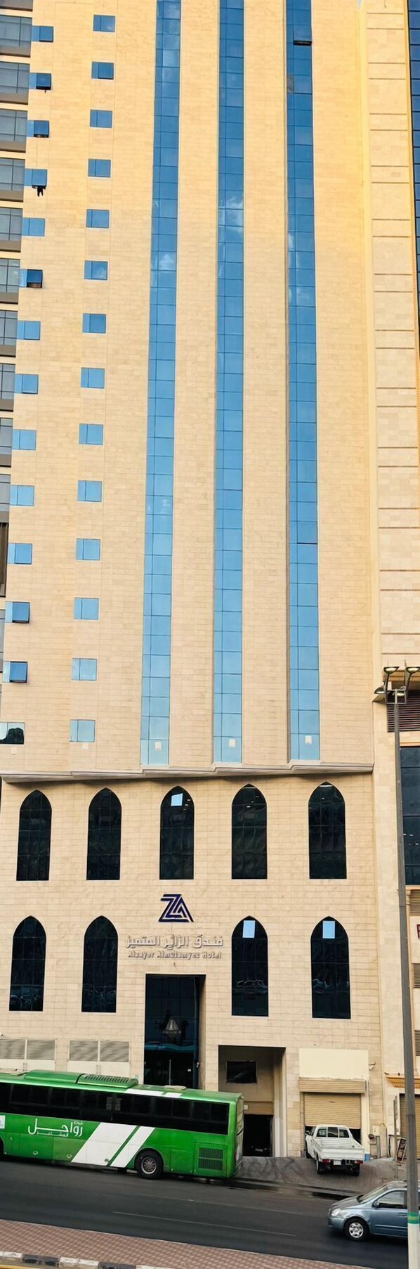 A tall building with a beige facade and large windows.