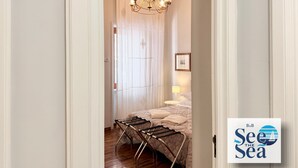 Quarto com cama, luminária pendente, mesa de cabeceira com abajur e quadro na parede.