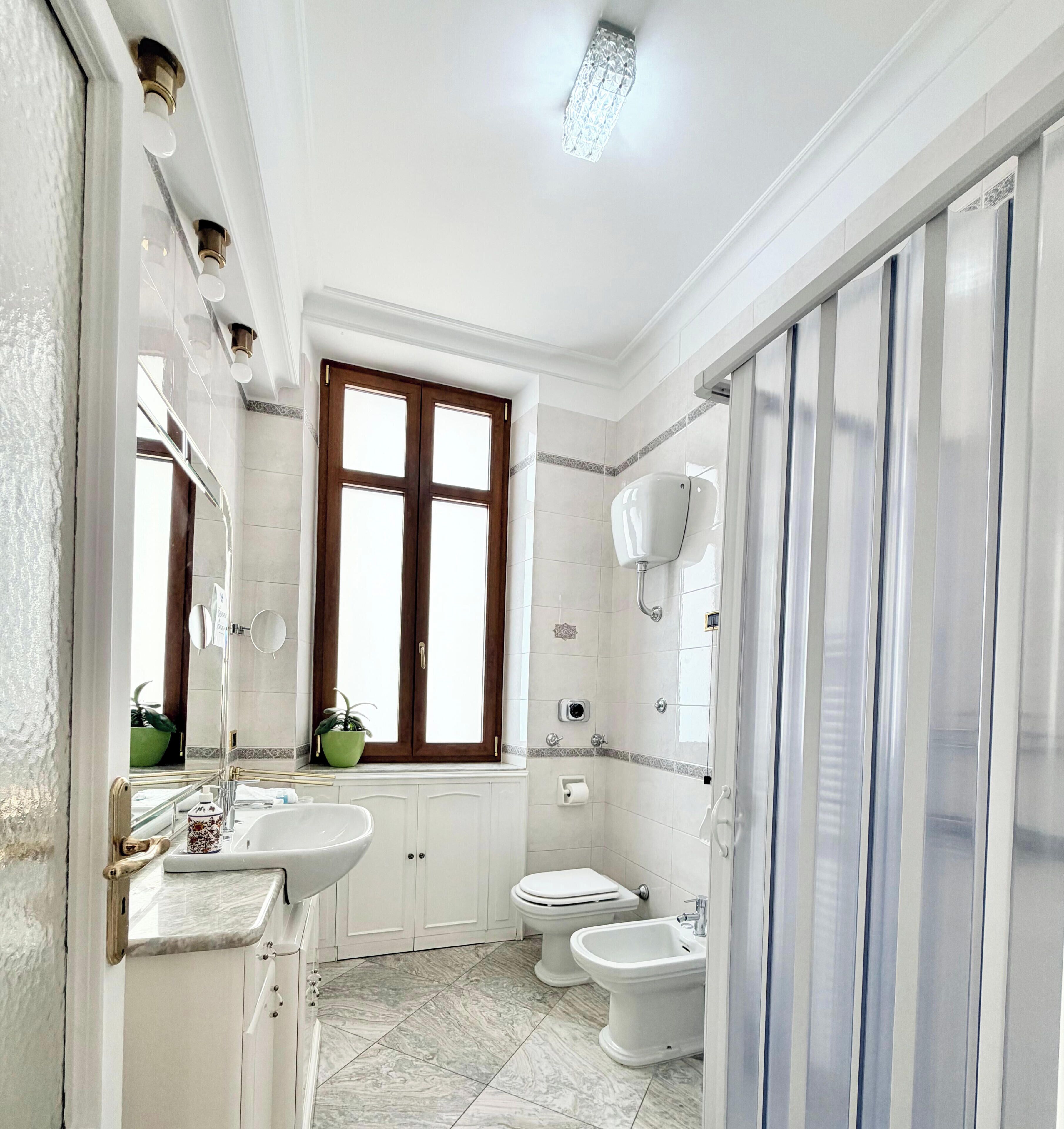 Une salle de bain équipée d’un lavabo, de toilettes, d’un bidet et d’un espace douche.