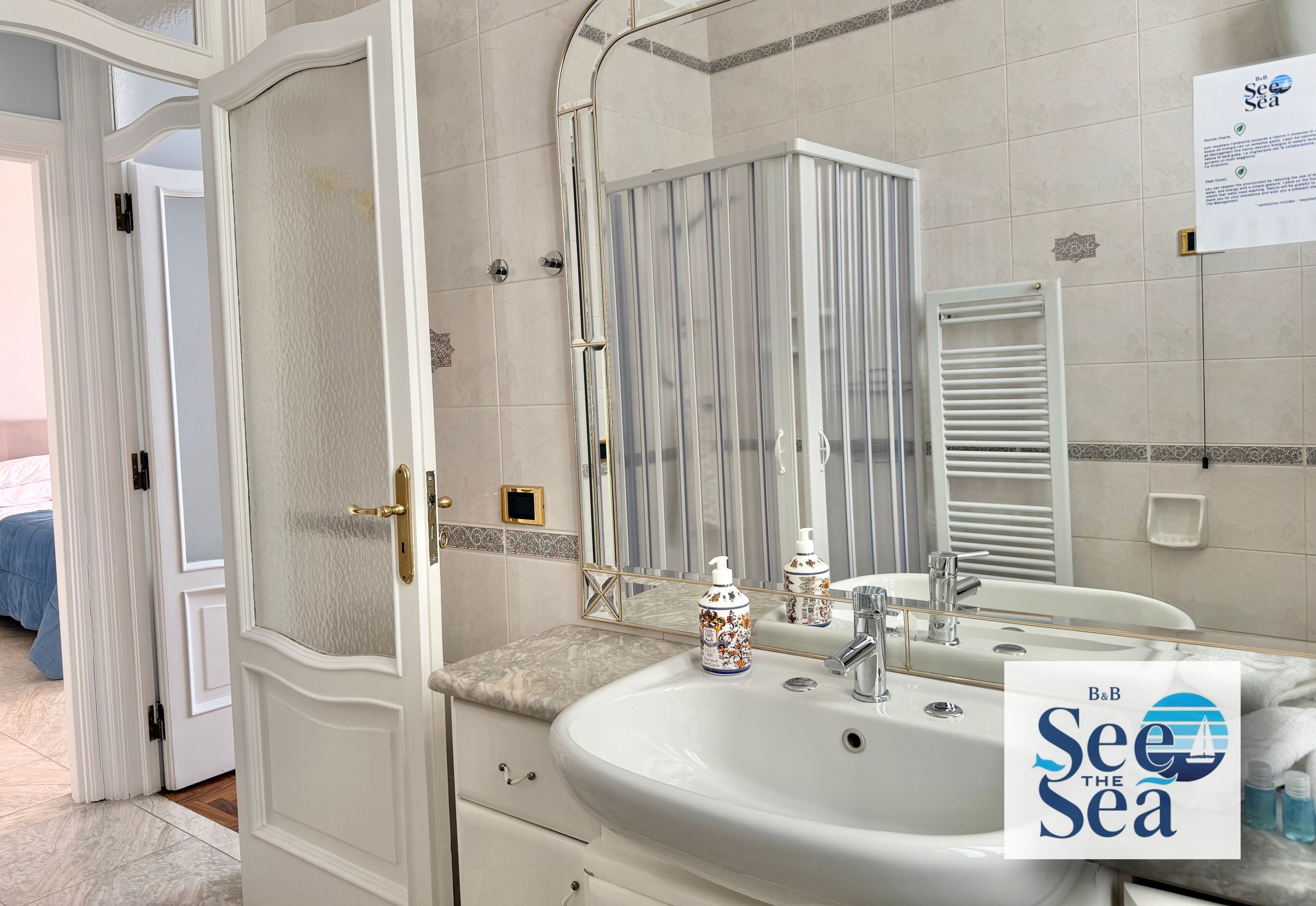 Une salle de bain avec un lavabo blanc, un miroir et des articles de toilette.