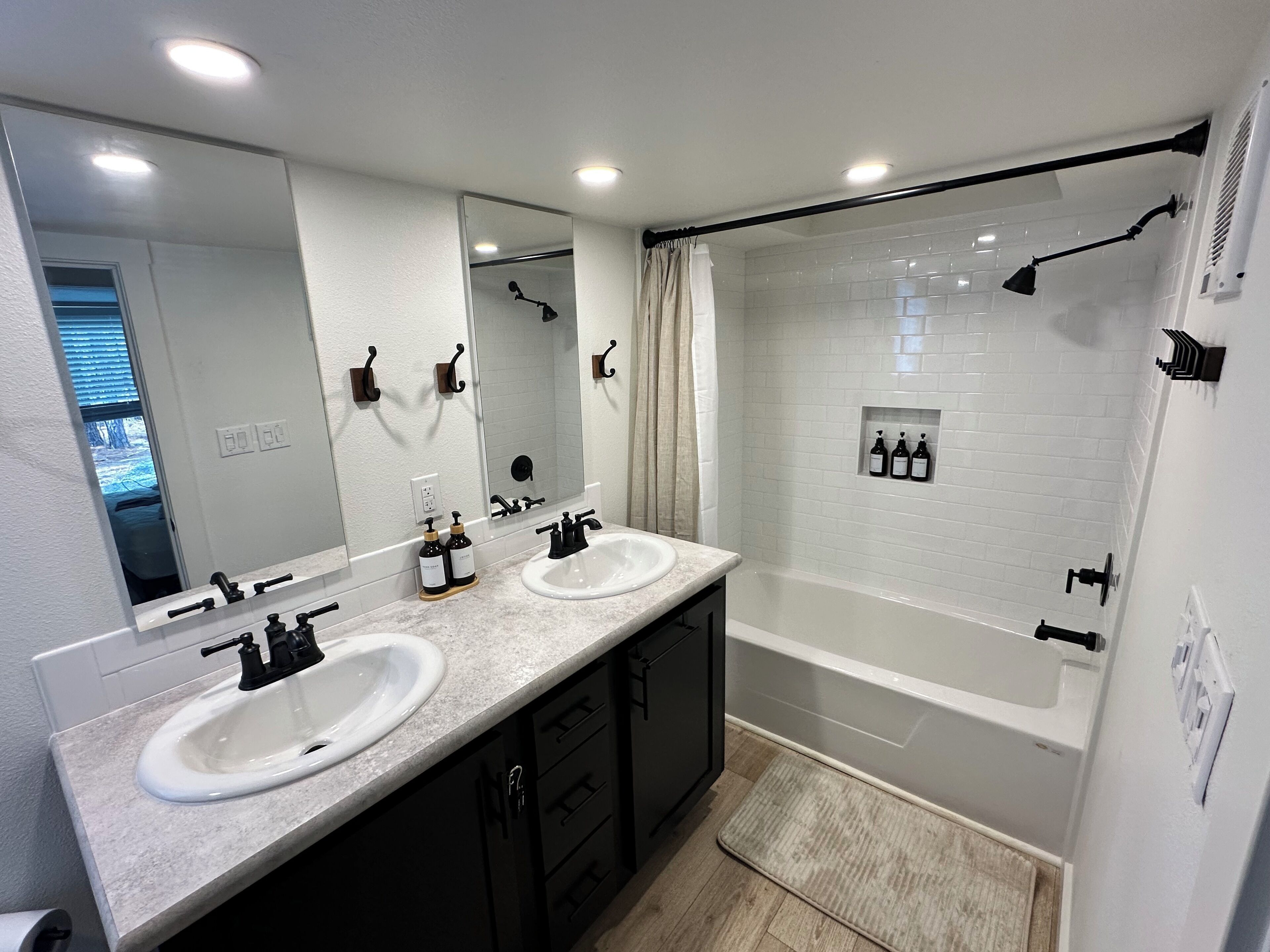 Une salle de bain moderne avec deux lavabos, un grand miroir et une douche à l’italienne.