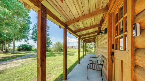 A wooden cabin with a covered porch, a bench, and a doorbell. - < 1 Mi to Casinos: Countryside Louisiana Getaway! (Duson)