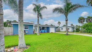 A residential house with a front yard, palm trees, and a blue exterior. - Walk to Shore + Pier: Family Home in Ormond Beach (Ormond Beach)