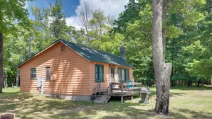 A small, single-story cabin with a green roof, surrounded by trees. - South Twin Lake Cabin w/ Dock, Steps to Water (Conover)