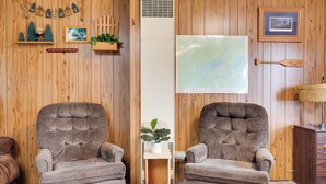 A room with two armchairs, a small table with a plant, a map on the wall, and a 'Welcome' sign. - South Twin Lake Cabin w/ Dock, Steps to Water (Conover)