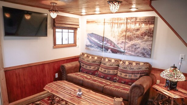 A cozy living room with a wooden sofa, a wooden coffee table, and a lamp.