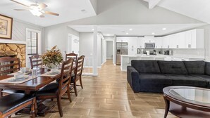 Una cocina moderna con armarios blancos, una isla central y electrodomésticos de acero inoxidable.
