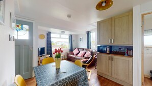 A compact living space with a dining table, a sofa, and a kitchenette.