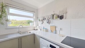 Eine Küche mit Fenster, Spüle, Toaster und Geschirrgestell.