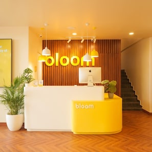 A reception desk with a wooden backdrop and a yellow sign.