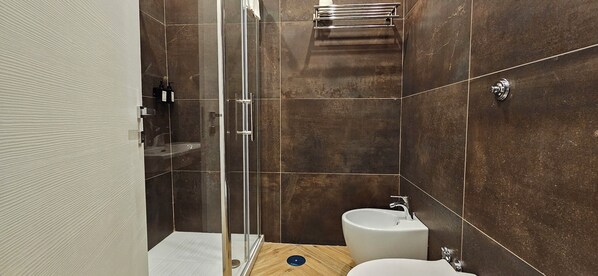 Un baño moderno con cabina de ducha de vidrio, lavamanos y tocador.