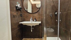 Un baño con lavamanos, espejo y ducha.