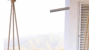 A person relaxing on a swing chair with a view of a mountainous landscape. - Reserva del Mar: Condominium with Ocean View (Santa Marta, Gaira)