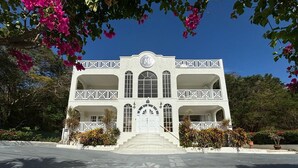 A two-story building with a central entrance, balconies, and a decorative facade.