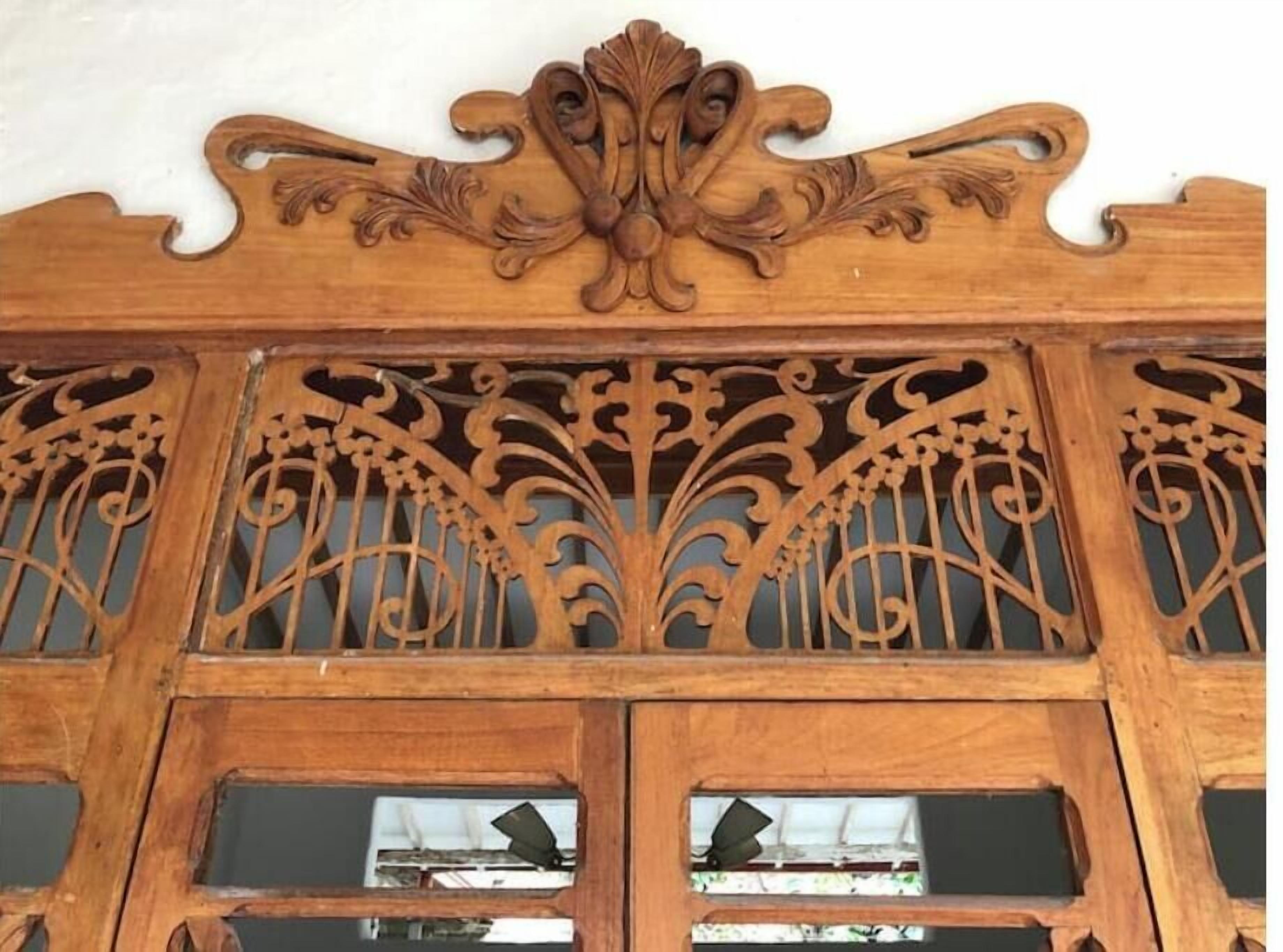 Een houten paneel met ingewikkelde houtsnijwerken en een centraal decoratief element.