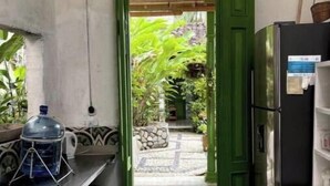 A kitchen with a green door leading to a patio area with plants and a tiled floor. - Room for couples in Palermo - Antioquia (Támesis)