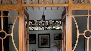 A wooden dining area with a patterned floor, a chandelier, and framed artwork on the walls.