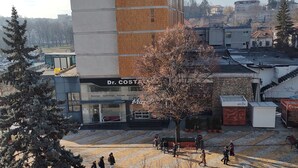 A building with a sign 'Dr. COSTA' and a wooden facade.